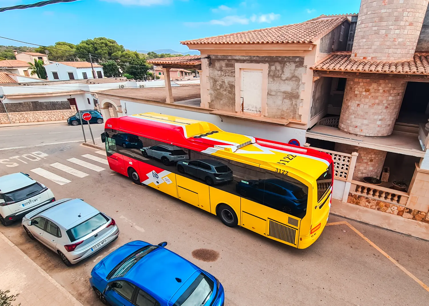 Red and yellow tib bus in Cala Figuera. Get around Mallorca using public transport.