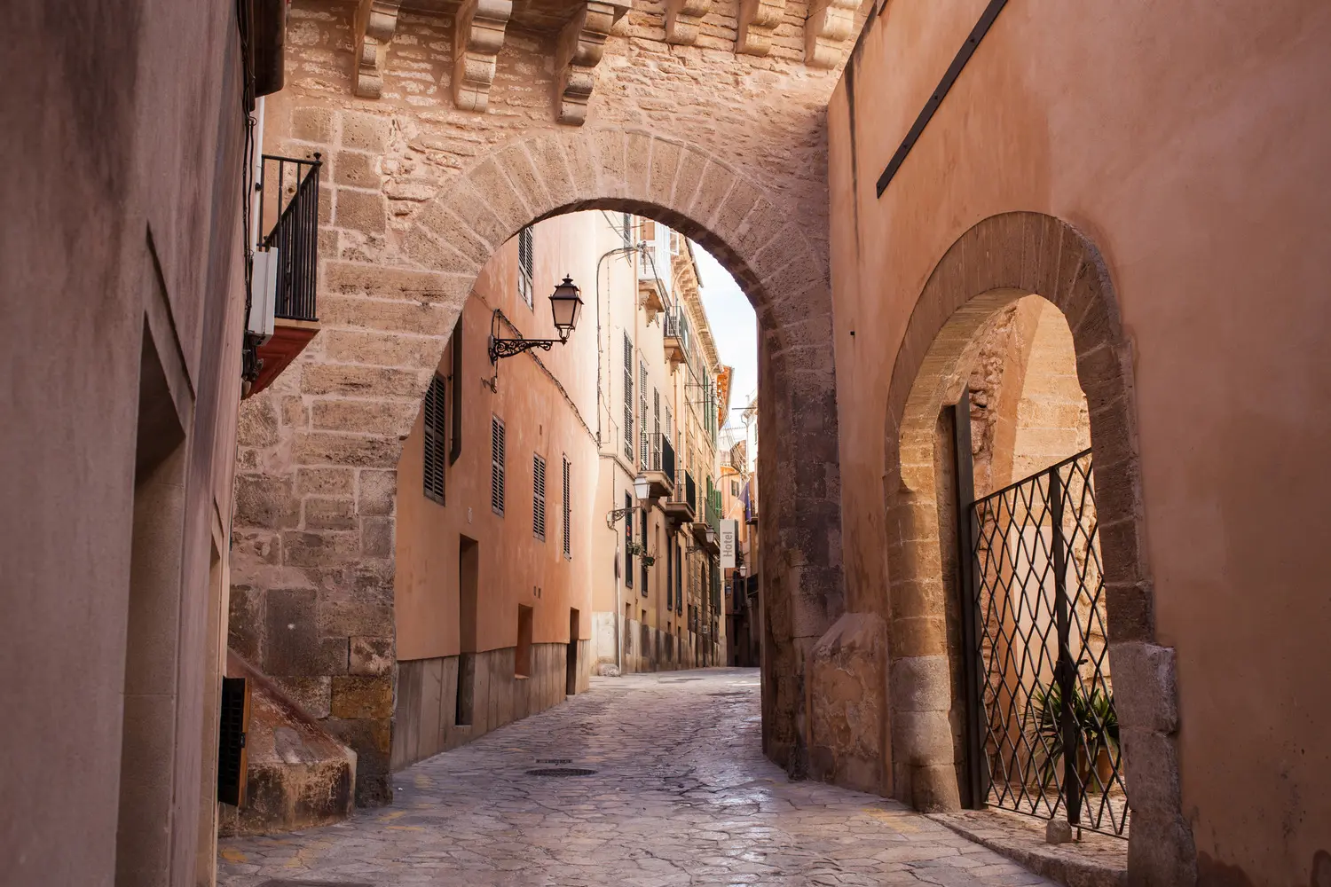 Stone arch and a narrow cobbled lane in Palma de Mallorca's Old Town