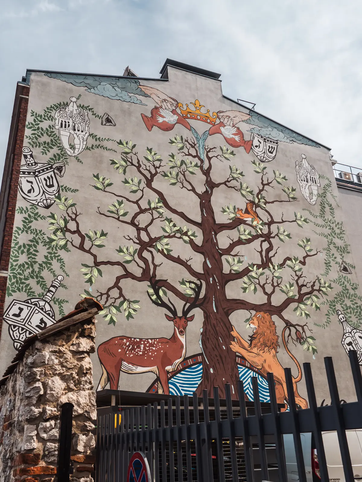 Jewish themed mural of a large tree, deer, lion and doves in Kazimierz, Krakow.