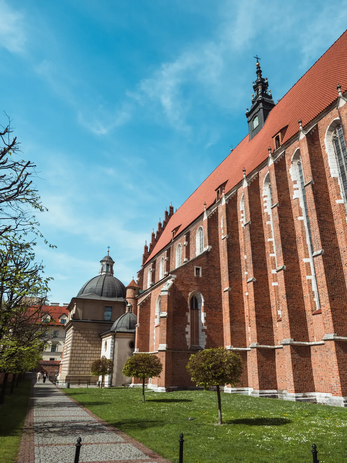 Towering red brick Corpus Christi Basilica in Kazimierz on a sunny day during a 2-day weekend itinerary in Krakow.