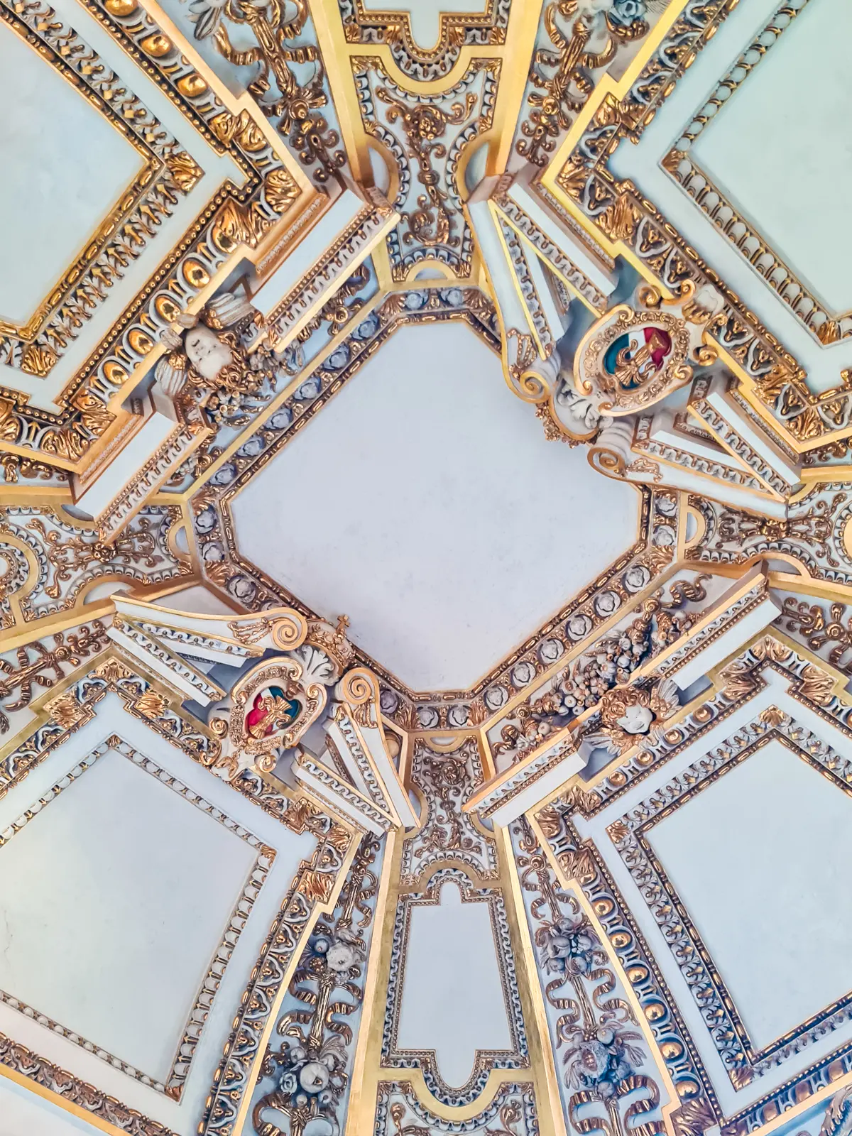 Close up of ornate roof with blue and gold details, white squares in the Royal Apartments at Wawel Castle.