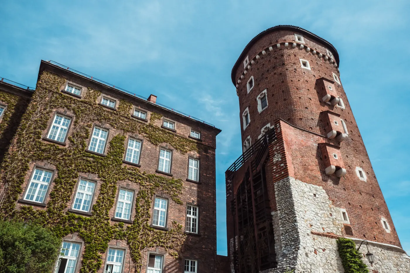 Red brick Sandomierska Tower with Medieval toilets at Wawel Castle seen from below on a sunny day.