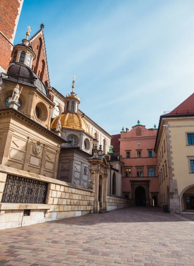 Two domes at Wawel Cathedral with many different architectural styles, Wawel Castle in the background on a sunny day, a must during your weekend in Krakow.