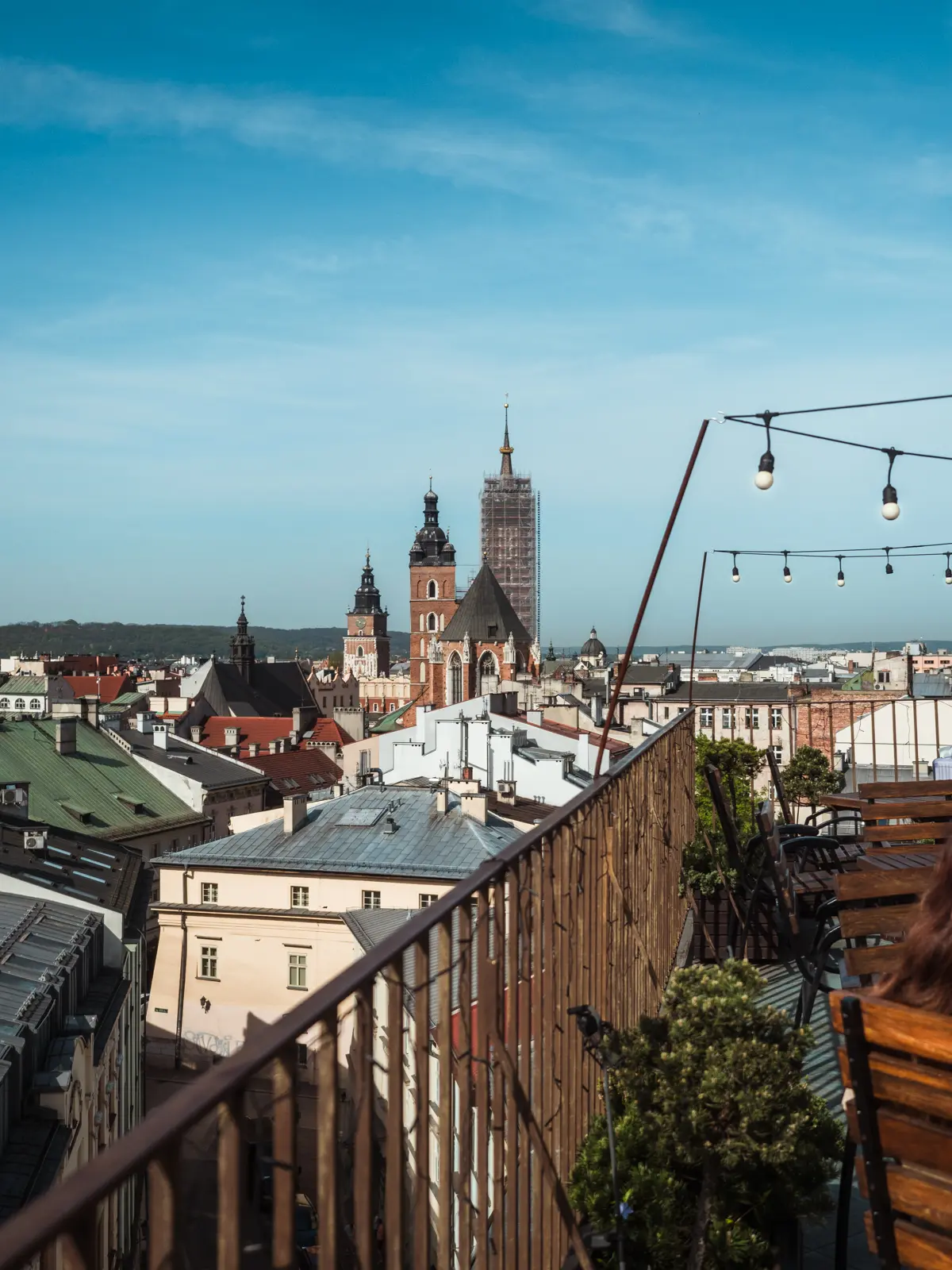 View over rooftops with St. Mary's Church in the background, from the balcony of Metrum Resto Bistro, a hidden gem in Krakow.