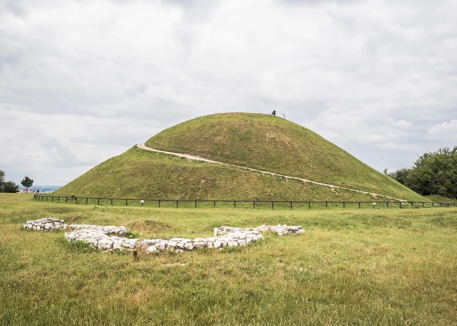 Green grass covered half dome called Krakus Mound, a hidden gem in Krakow offering incredible views.