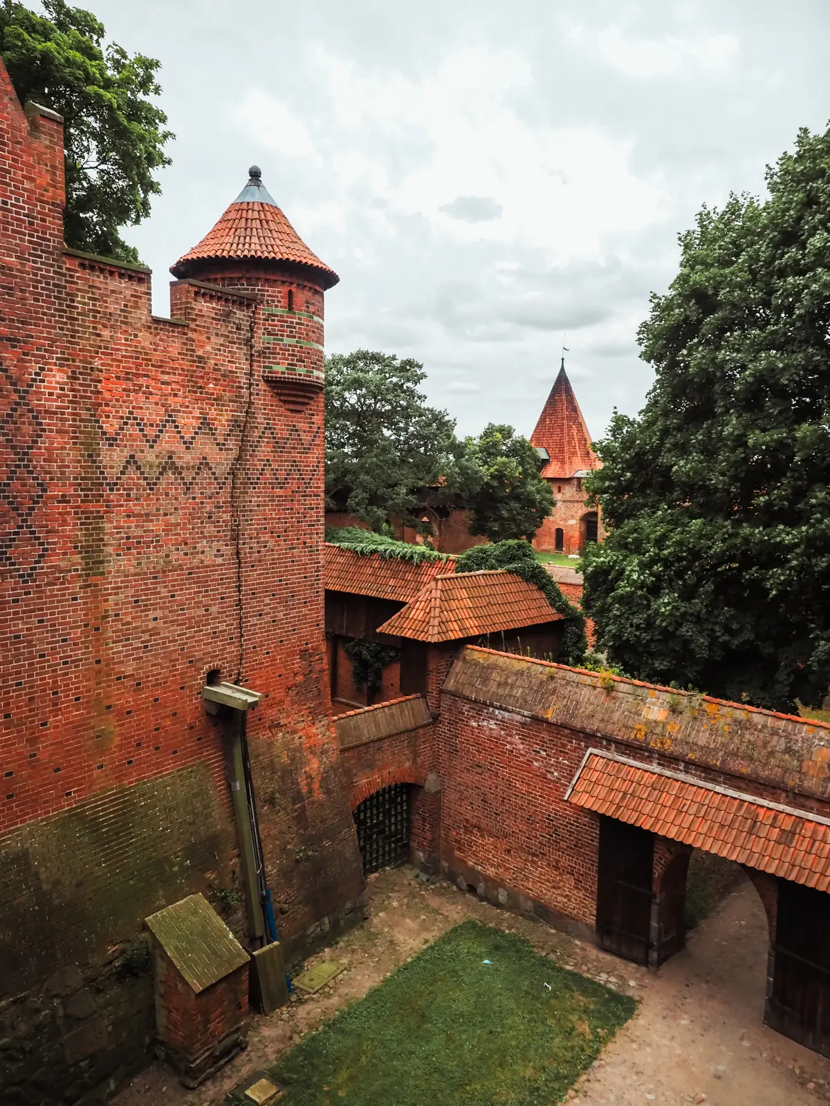 Looking out over the courtyard, red brick walls and towers at Malbork Castle in Poland.