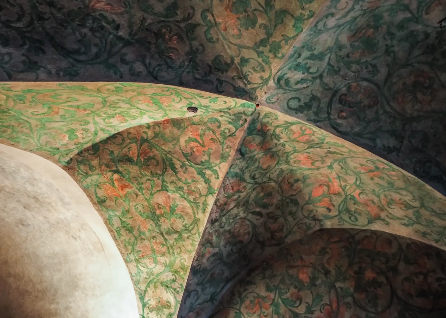 Green and orange painted pattern on the ceiling of a bedroom in Malbork Castle.