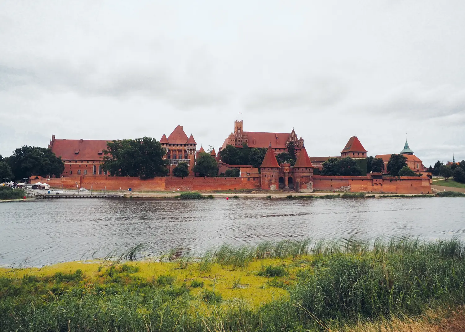 View of the red brick Malbork Castle from the other side of the river. Best Malbork Castle viewpoint.