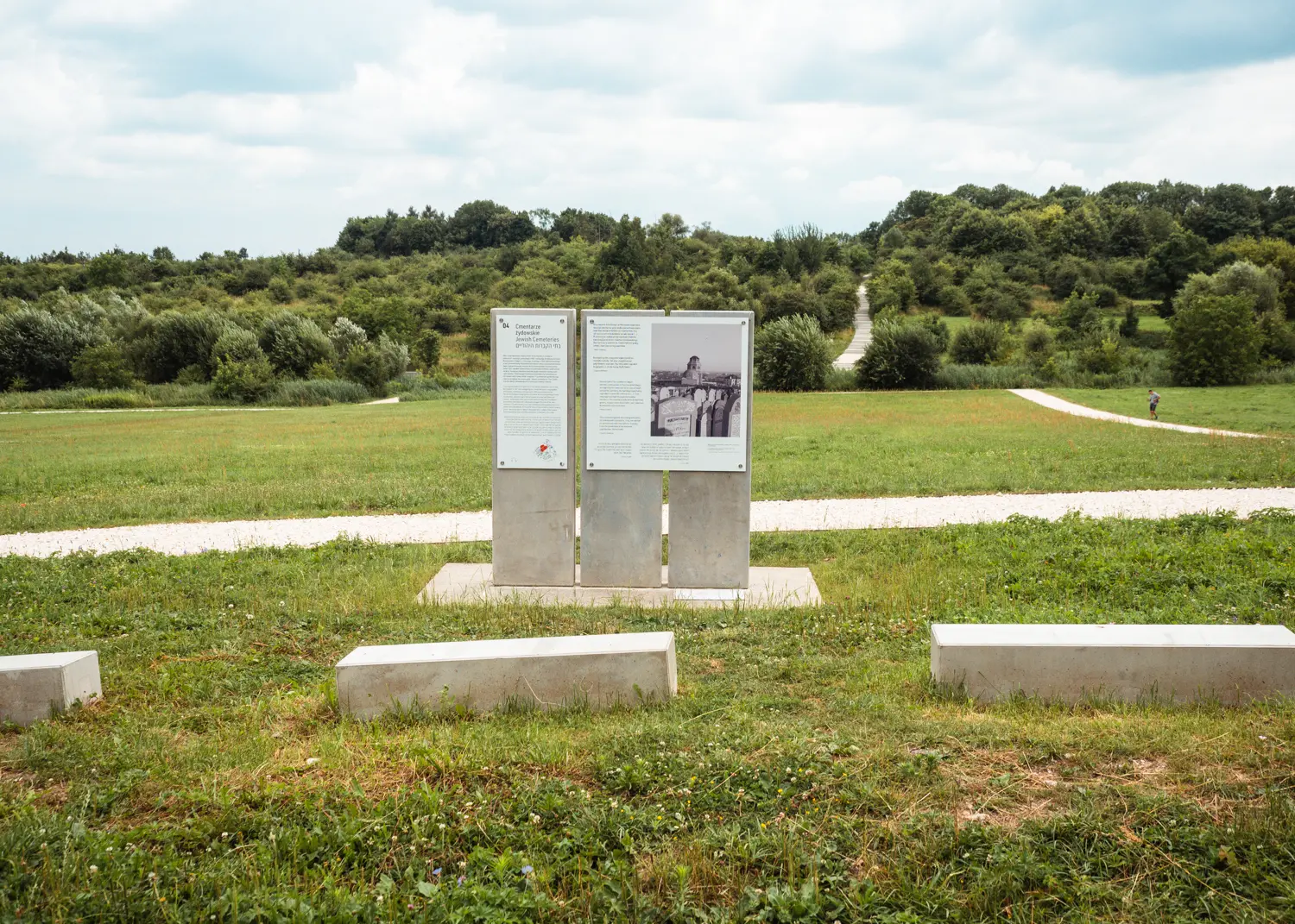 Information plaques on cement blocks on a large green field, the former ares of Plaszow Concentration Camp, a hidden gem in Krakow.