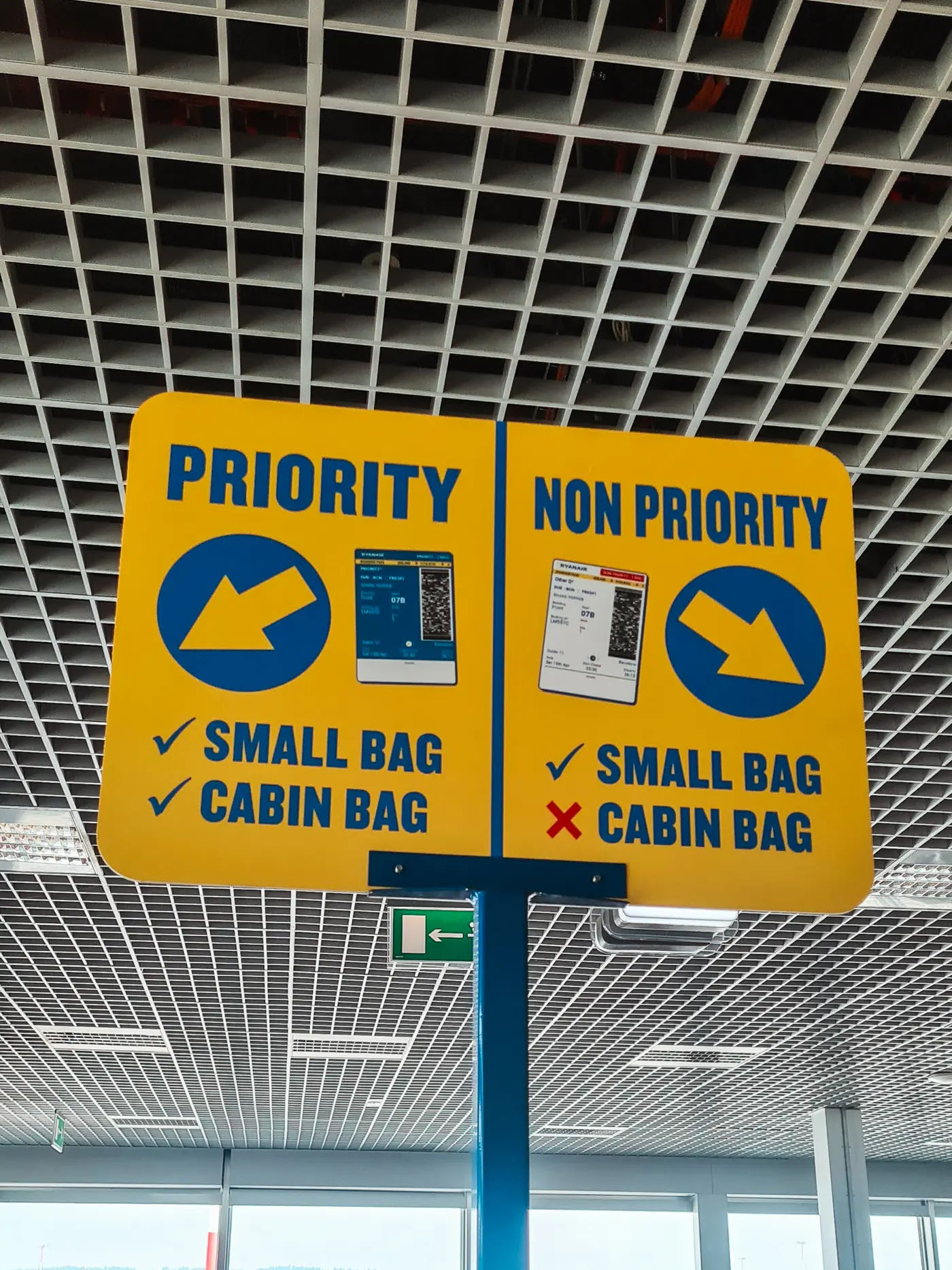 Yellow Ryanair sign with blue text at the gate airport guiding people into priority and non priority lines.