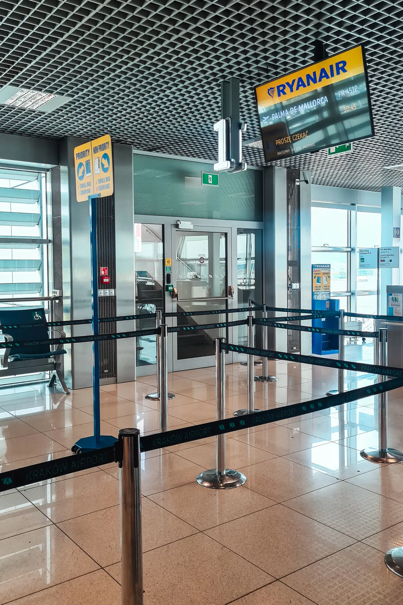 Ryanair gate at an airport with roped lines for priority and non priority passengers.