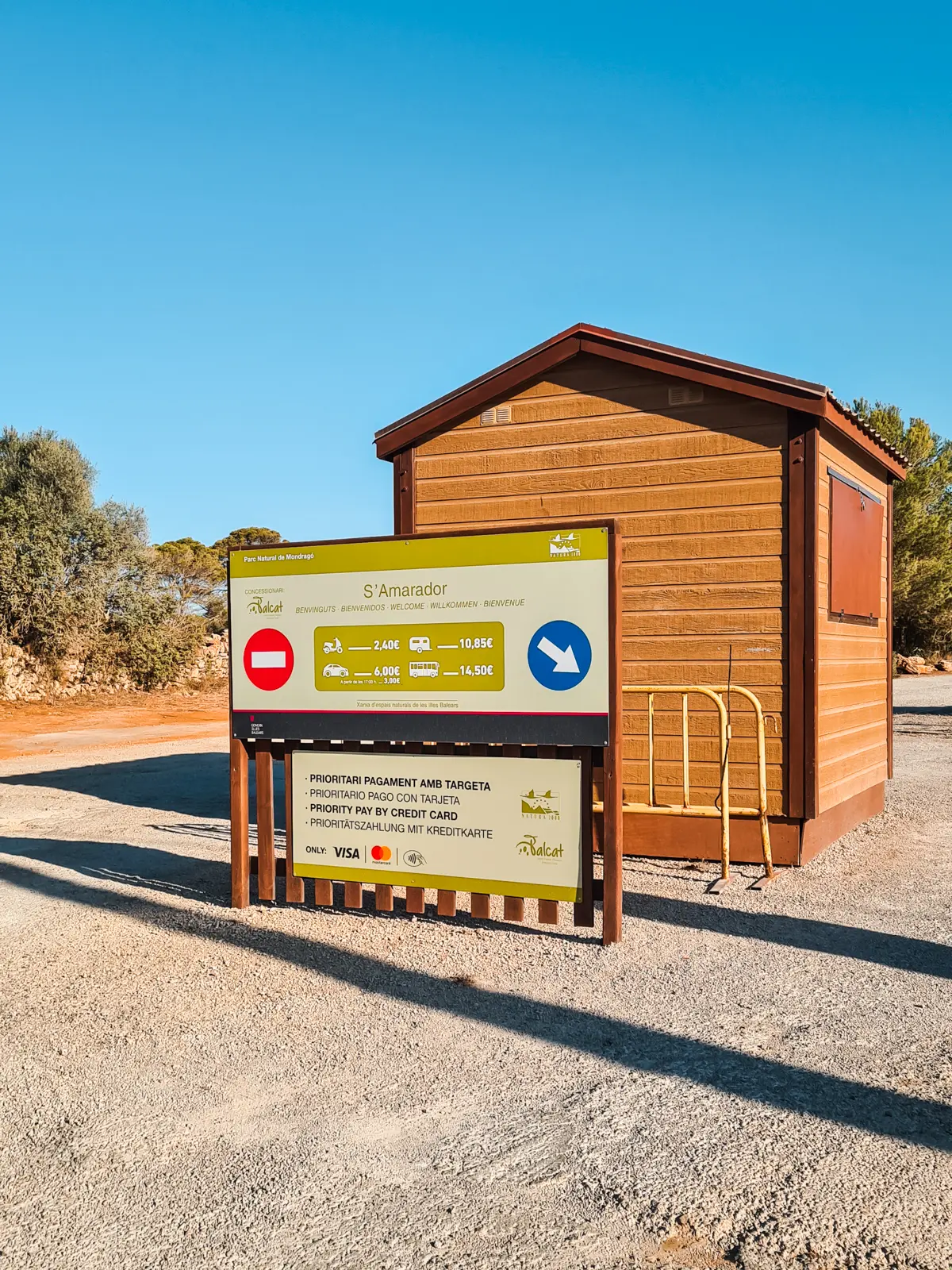 Sign and small hut at the entrance of Cala S'Amarador Parking lot in Mondrago Natural Park in Mallorca.