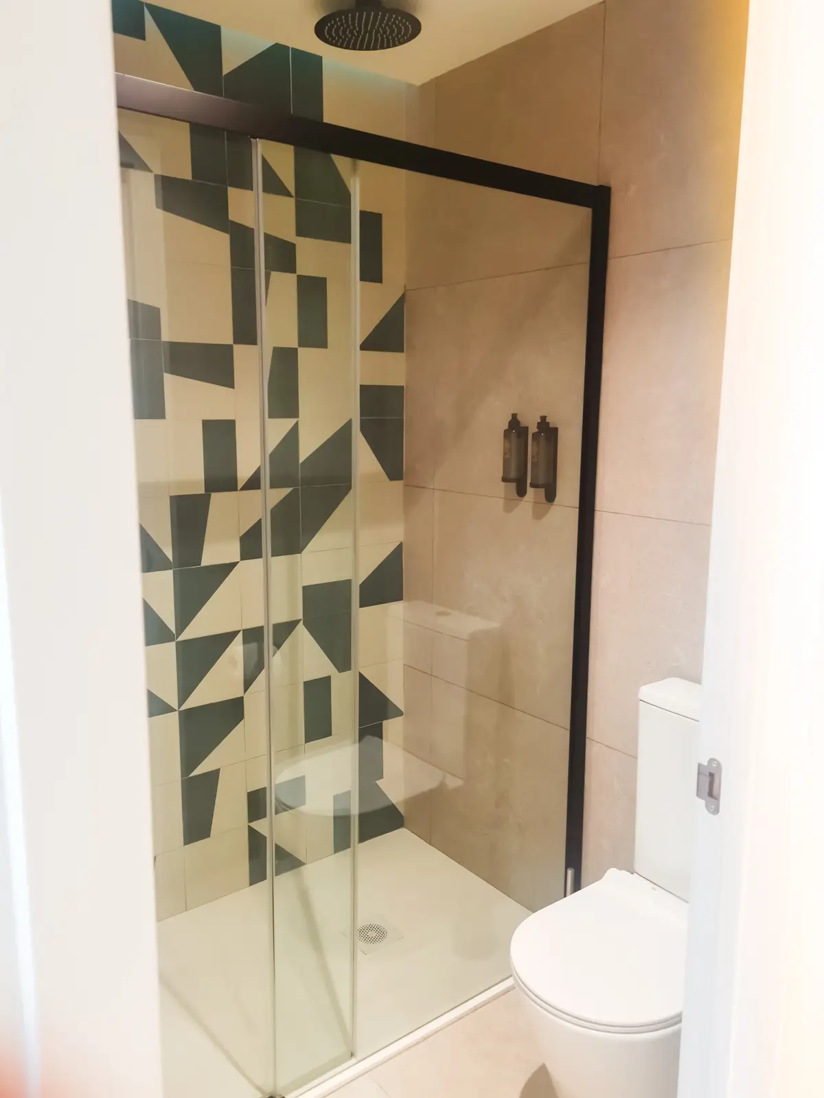 White and green tiles in a random pattern in the shower at Hotel Santanyi Port in Cala Figuera, Mallorca.