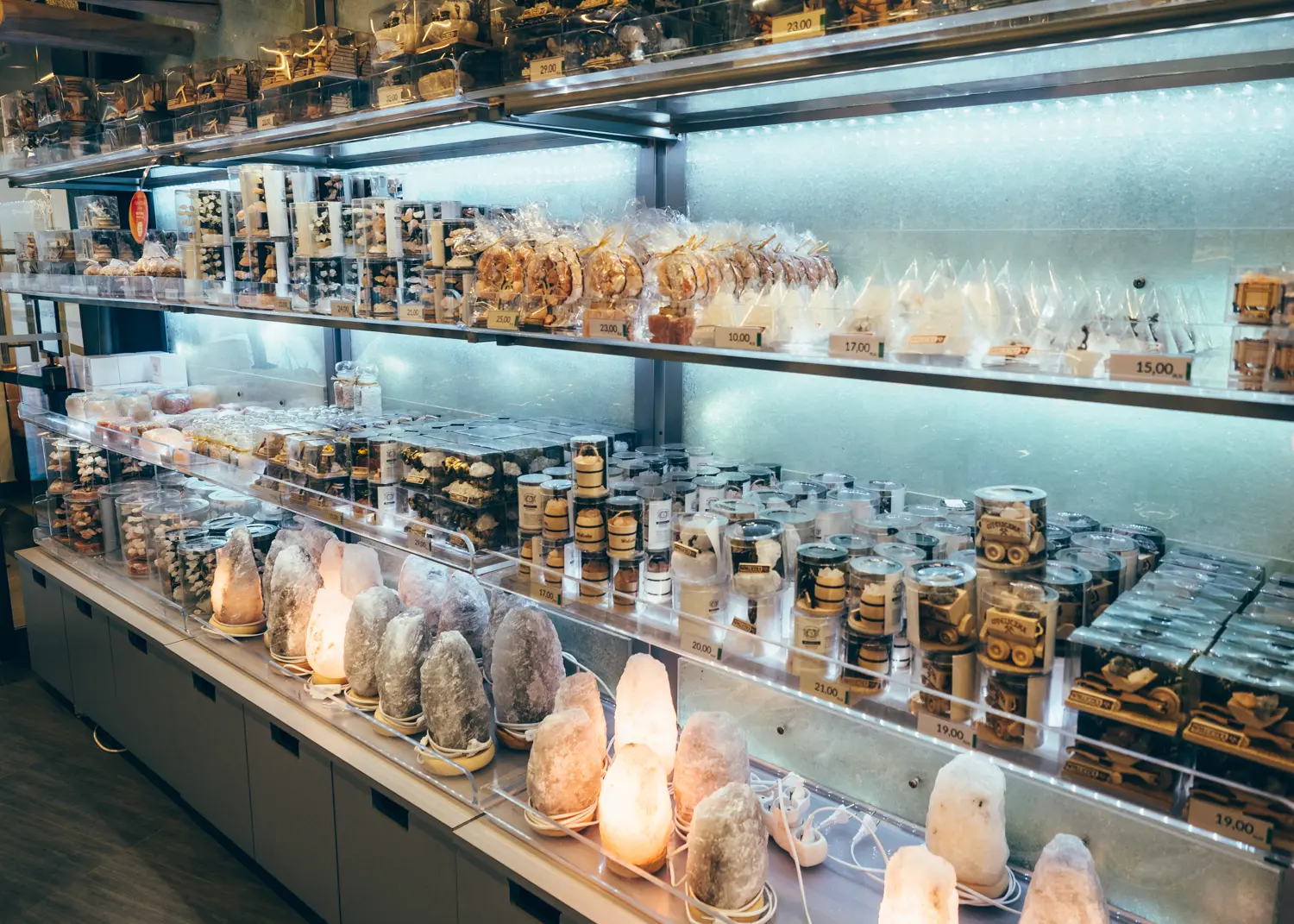 Salt lamps and other salt souvenirs on glass shelves in the gift shop in Wieliczka Salt Mine.