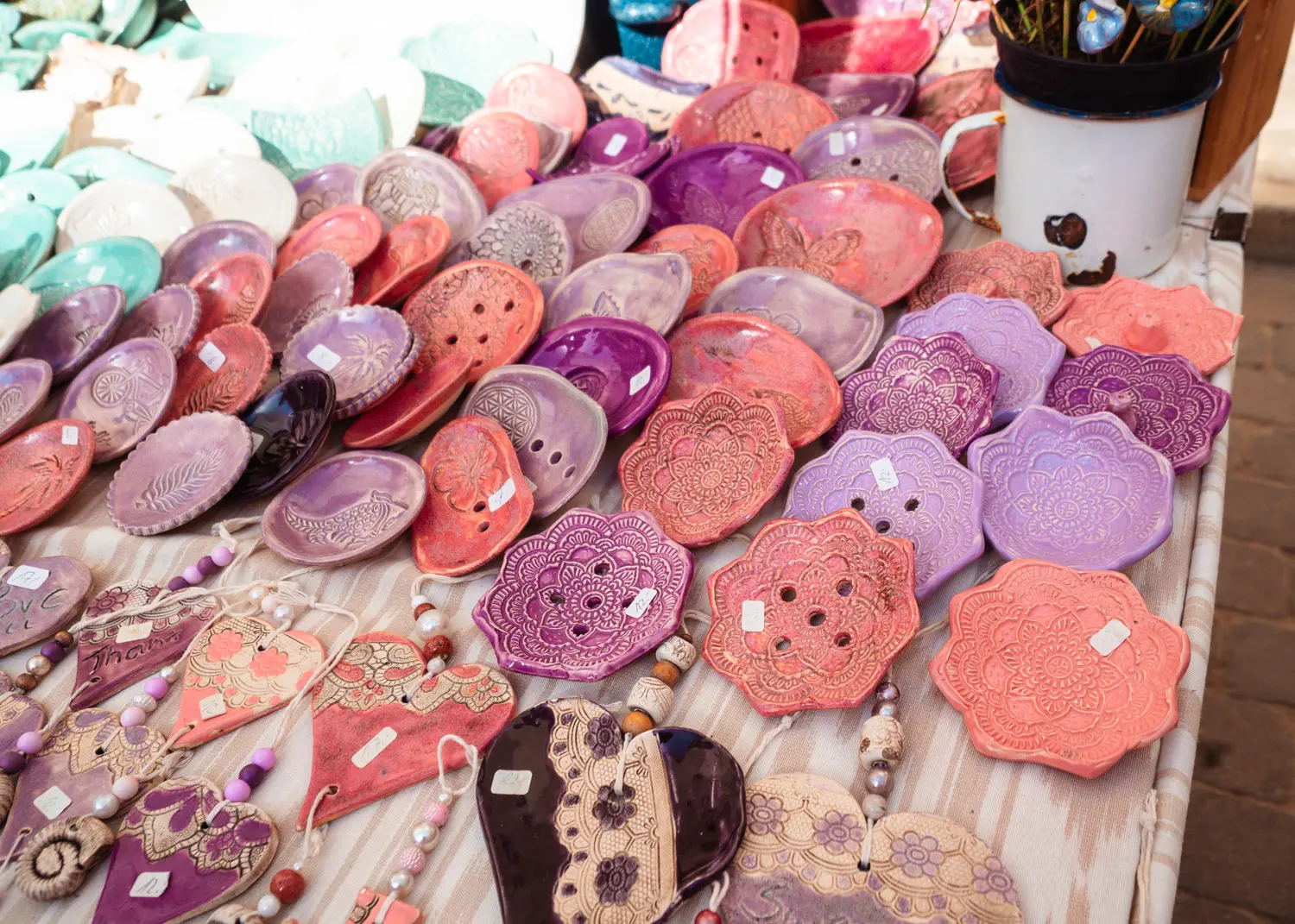 Table with pink and purple handmade trays at Santanyi Market close to Cala Figuera in Mallorca.