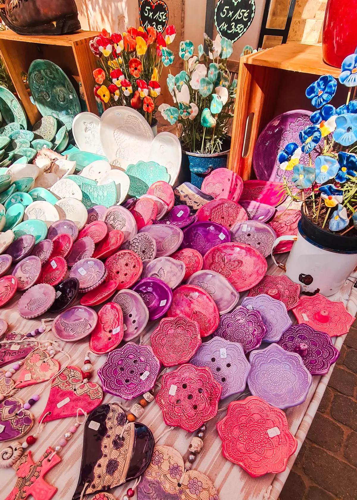 Table with pink and purple handmade trays at Santanyi Market in Mallorca.