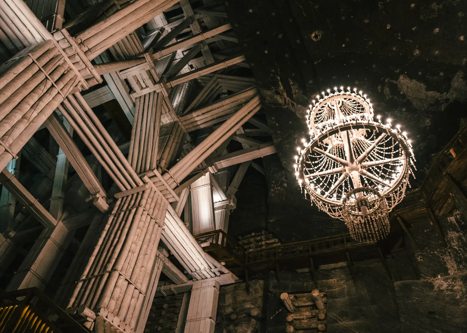 Wood scaffolding holding up the roof and a chandelier made of salt in Wieliczka Salt Mine, Krakow.