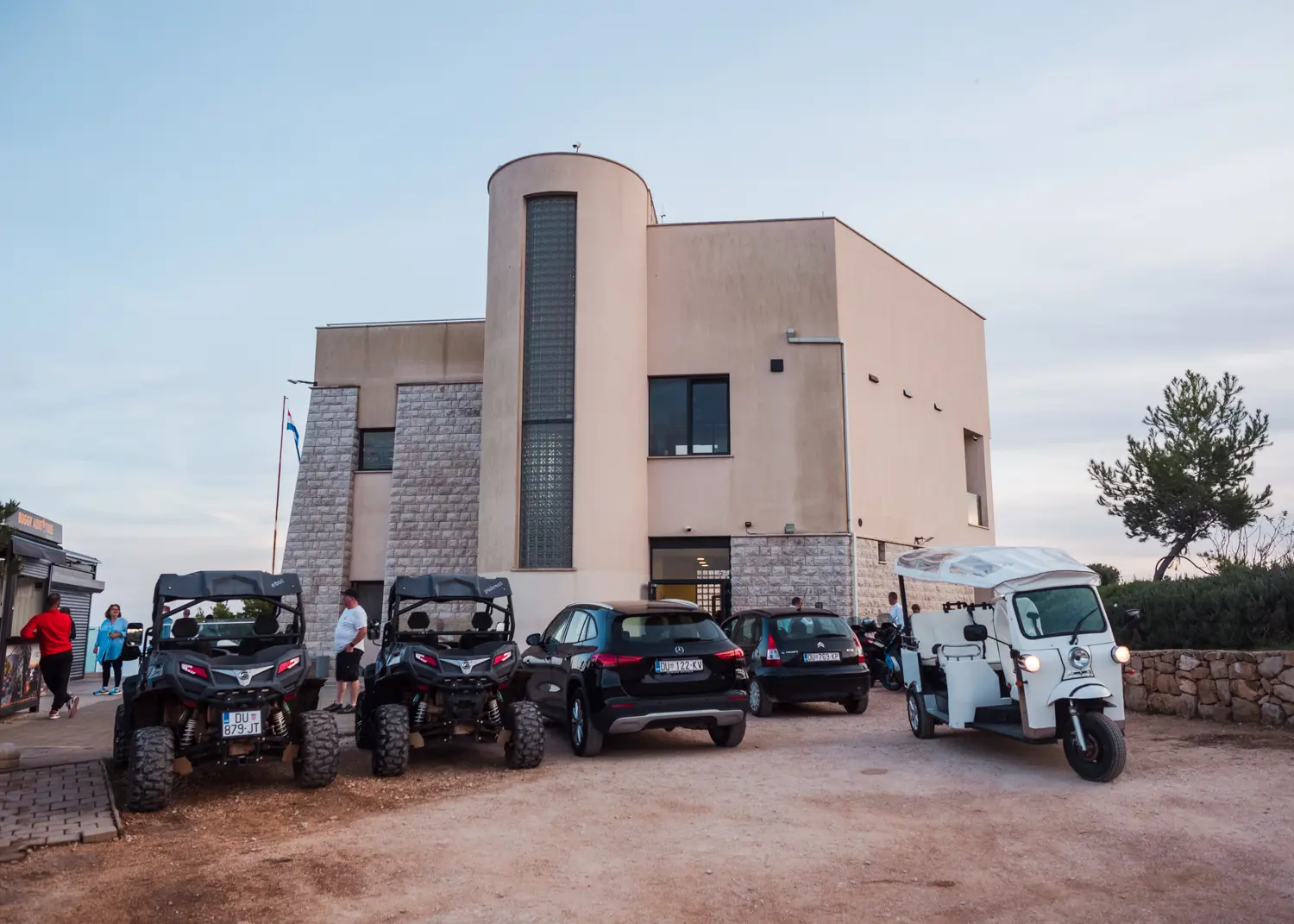 Buggies in front of the beige cable car building on top of Mount Srd in Dubrovnik. Join a guided tour.