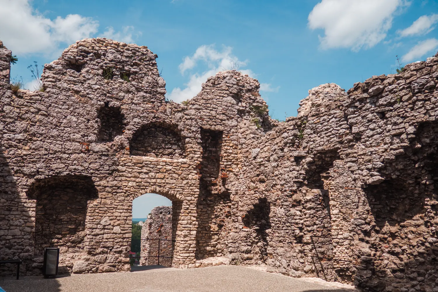 Close up of ruin stone walls with an arched opening at Ogrodzieniec Castle, a haunted castle in Poland.