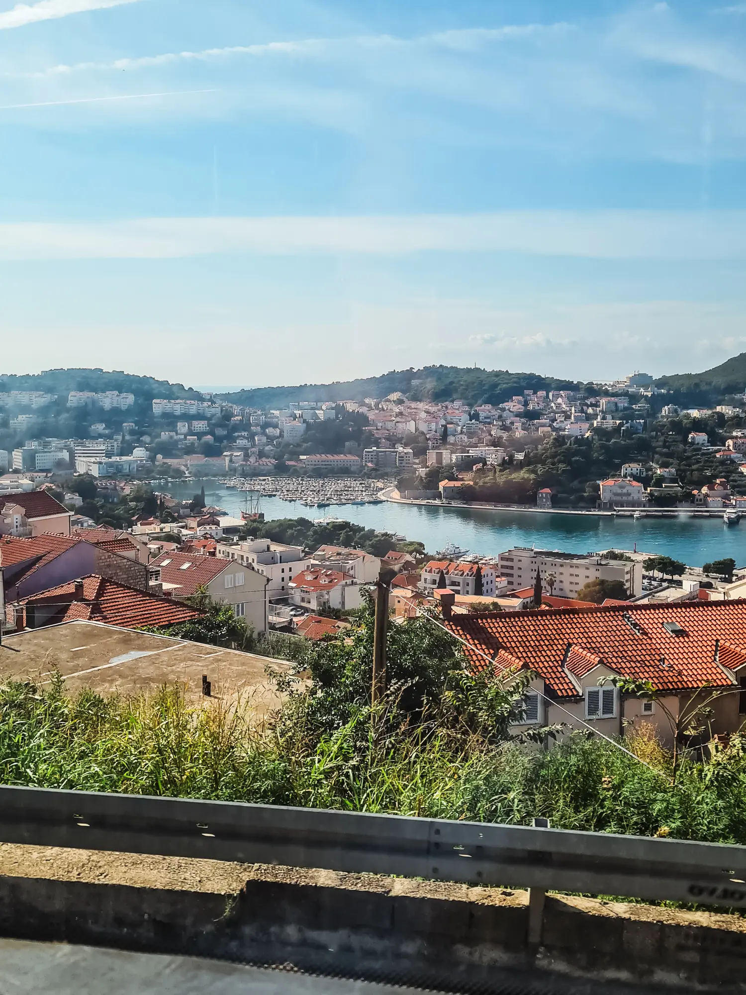 View from the bus window of Dubrovnik harbor lined with orange roofed houses on both sides, on the way to Kotor, Montenegro.
