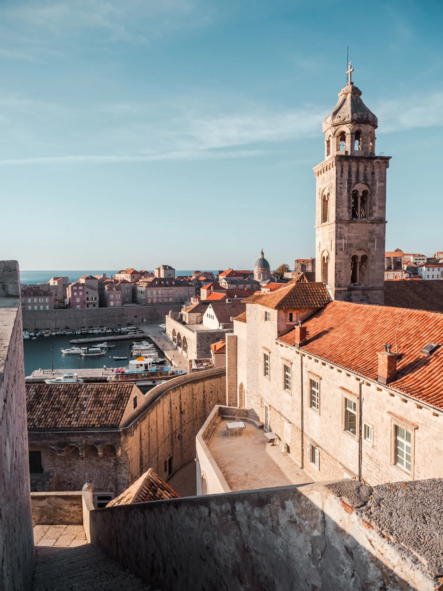 View of beige sandstone buildings with orange roofs seen from the city walls during an Old Town walking tour in Dubrovnik.