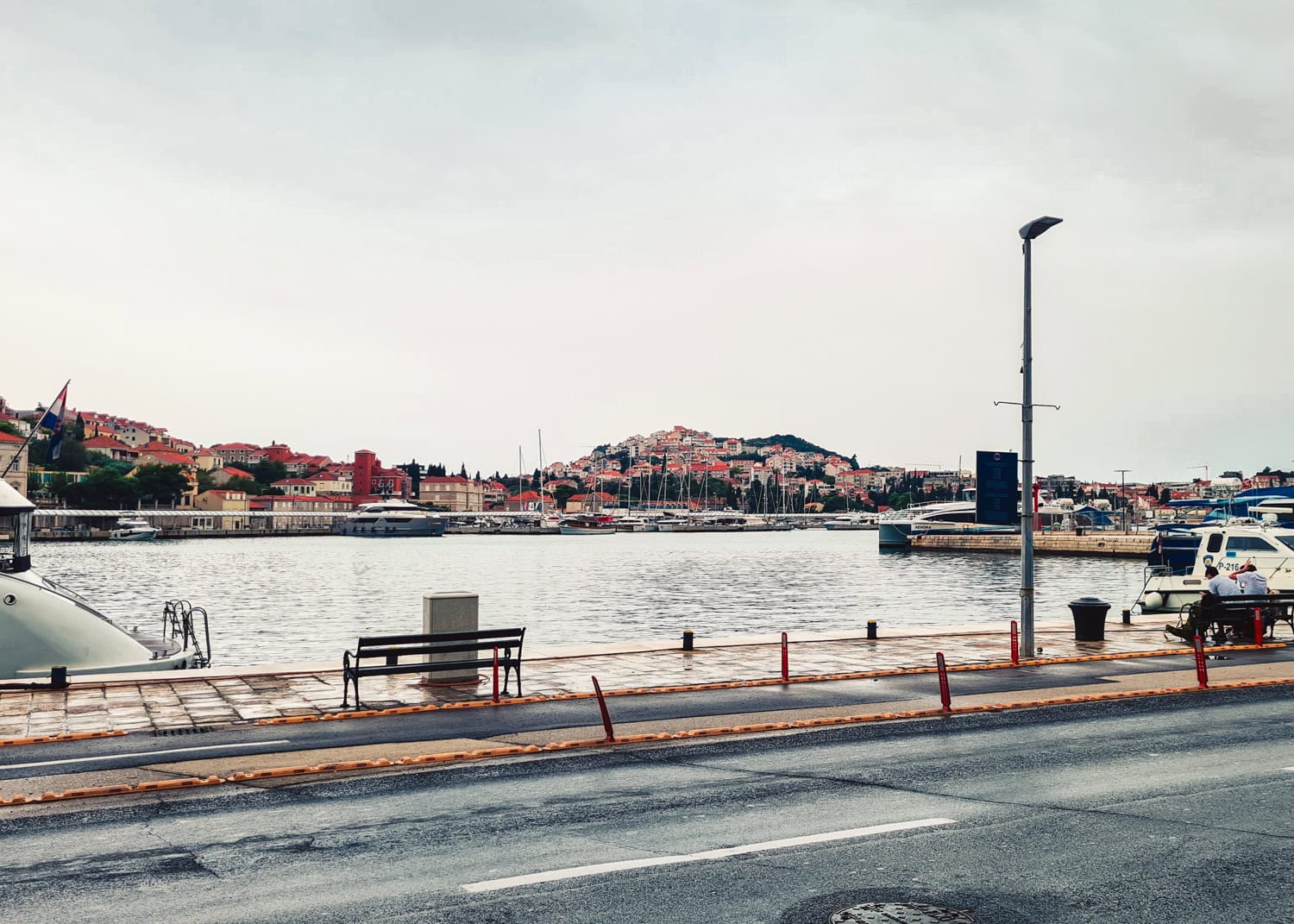 View from the road of Gruž harbor with the houses in Lapad in the background, one of the most affordable places to stay in Dubrovnik.