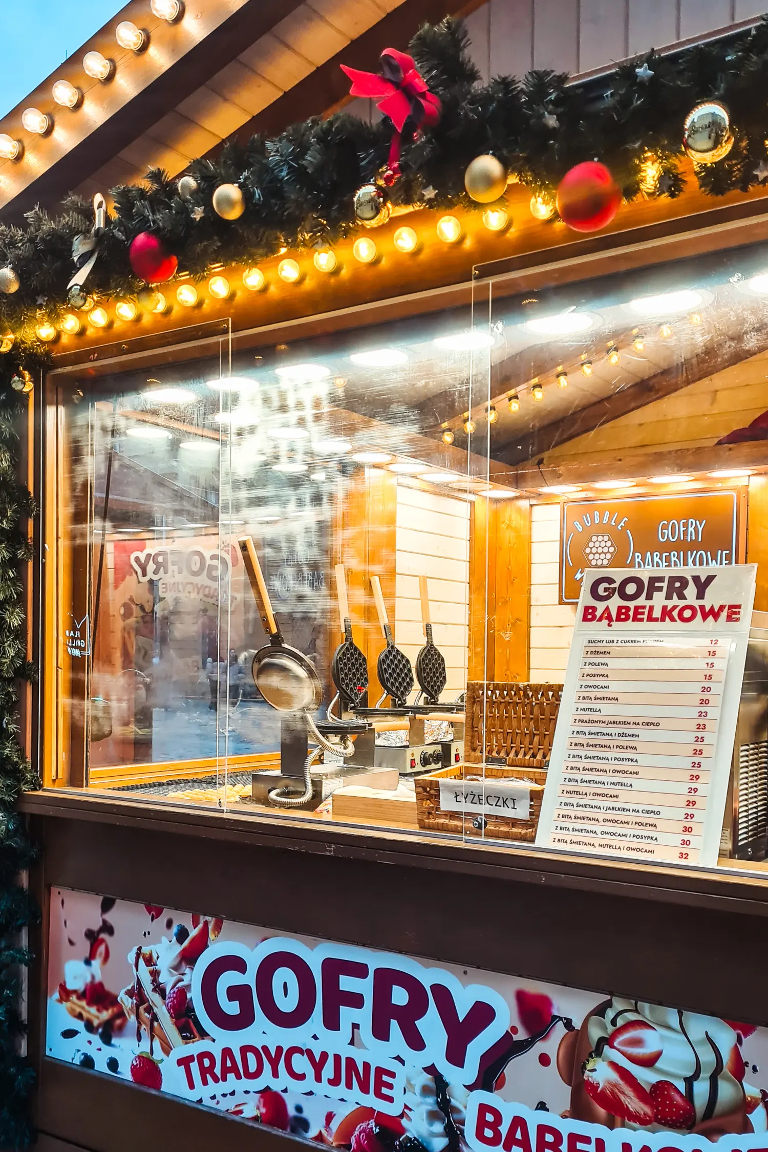 Close up of a gofry (waffle) stall decorated with garlands and lights at Wroclaw Christmas Market.