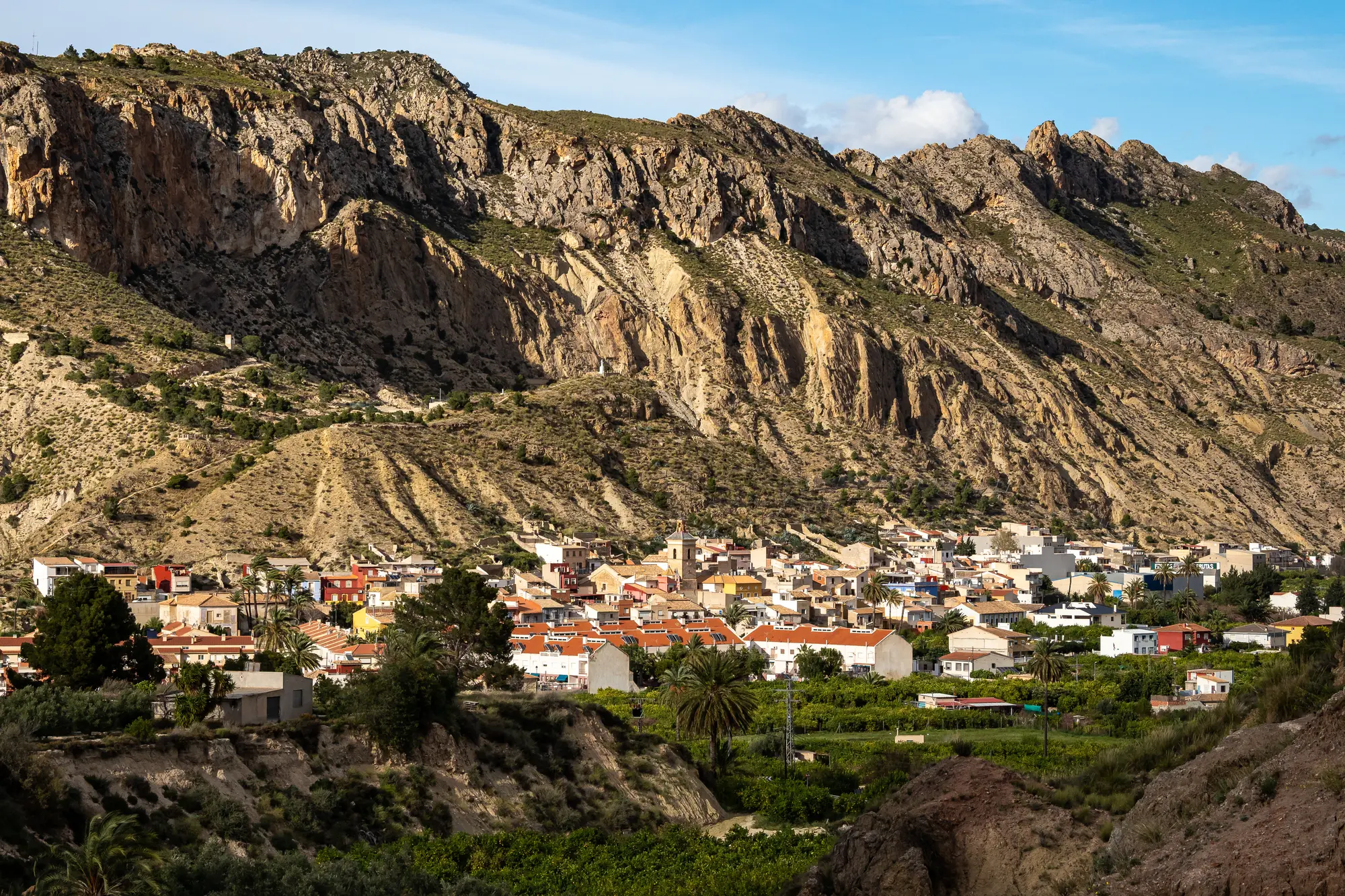 View of the small Spanish village, Villanueva del Río Segura, at the foot of a mountain surrounded by greenery, in Ricote Valley, Murcia.