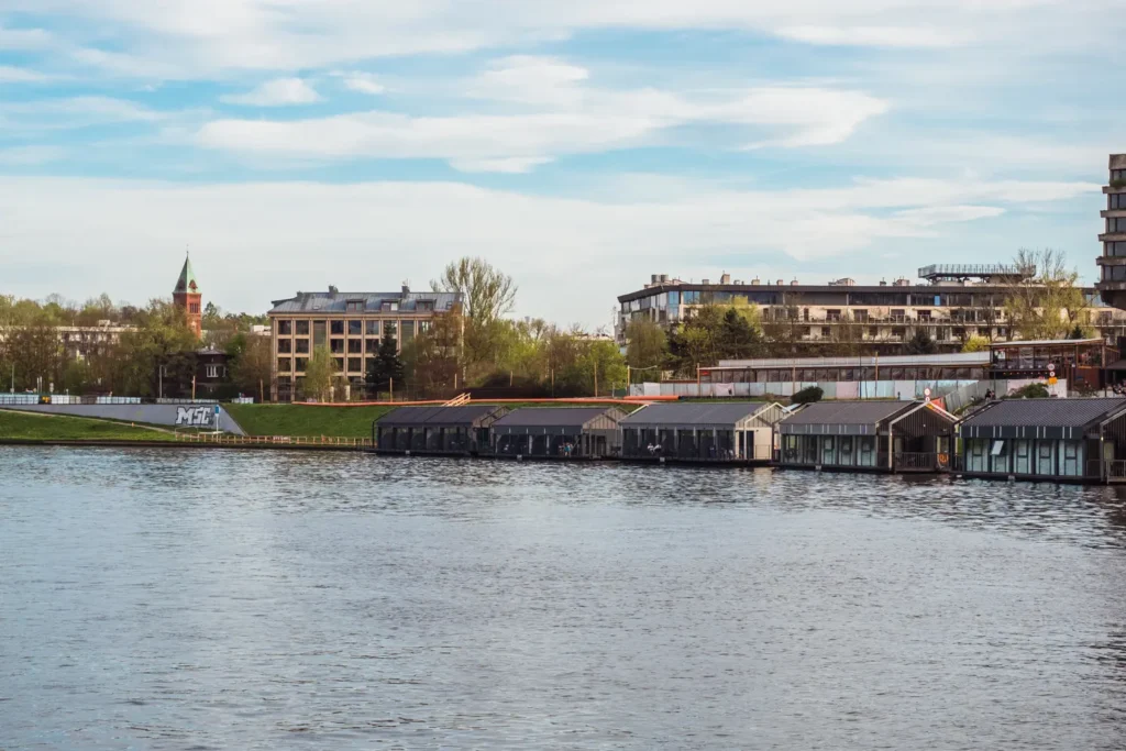 View of five dark houses part of the floating New Port hotel on the river, one of the best hotels in Krakow.