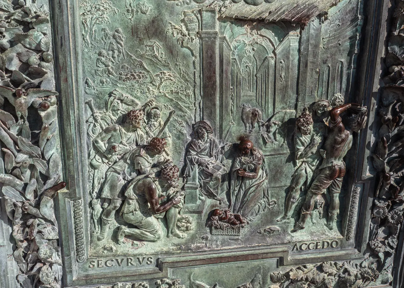 Close up of a panel of the bronze (with a green hue) doors in the Cathedral of Pisa. Depicting a scene with 10 people.