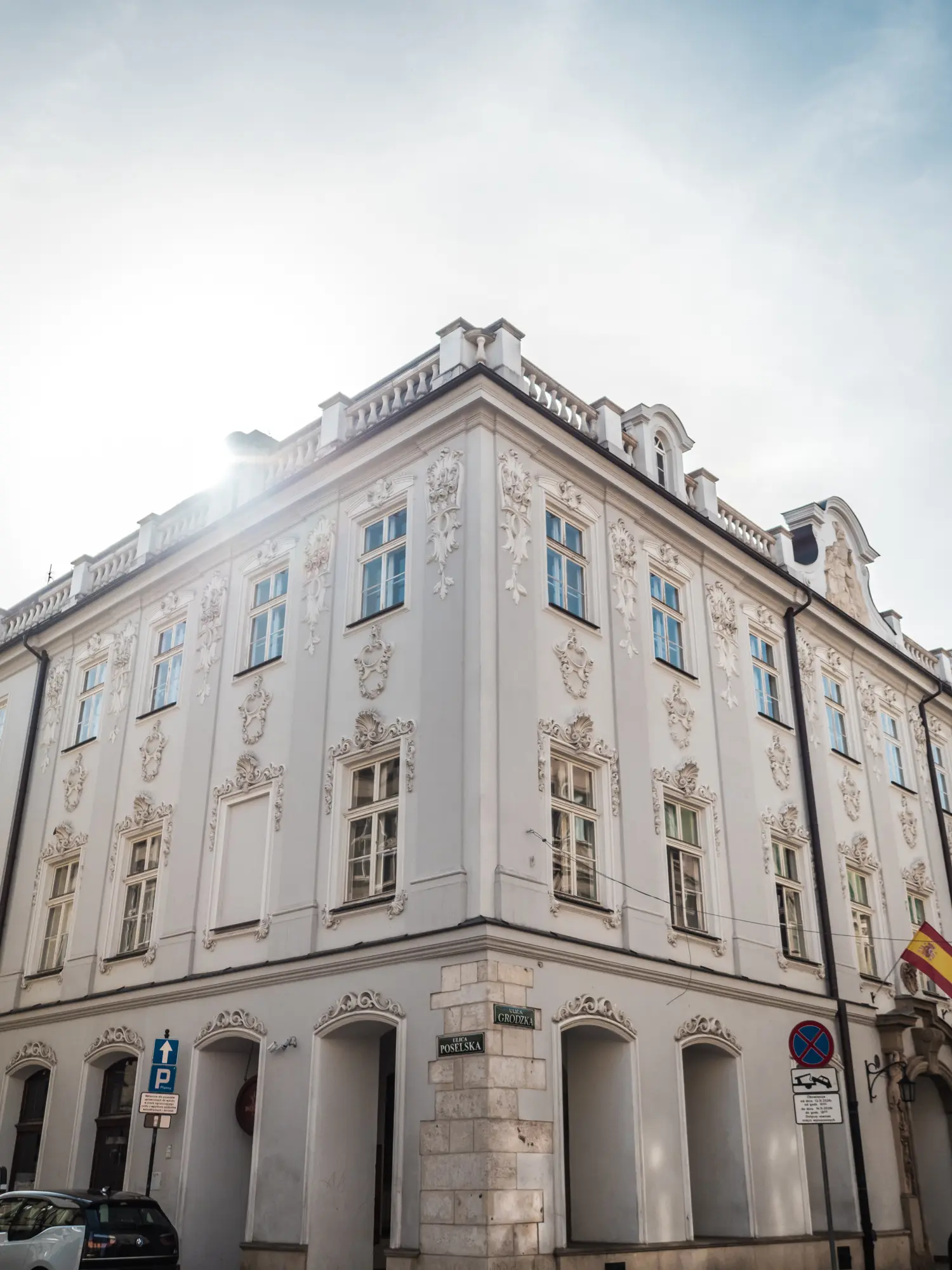 Sun shining in over a beautiful light grey building with ornate detail on the walls in the Old Town, where to stay in Krakow.