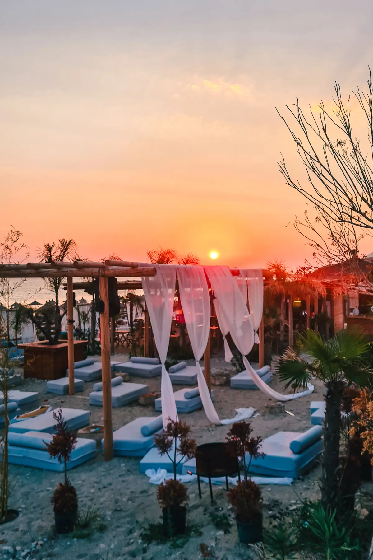 View of a large cabana area with blue pillows on the sand at a beach club on Drymades Beach on the Albanian Riviera.