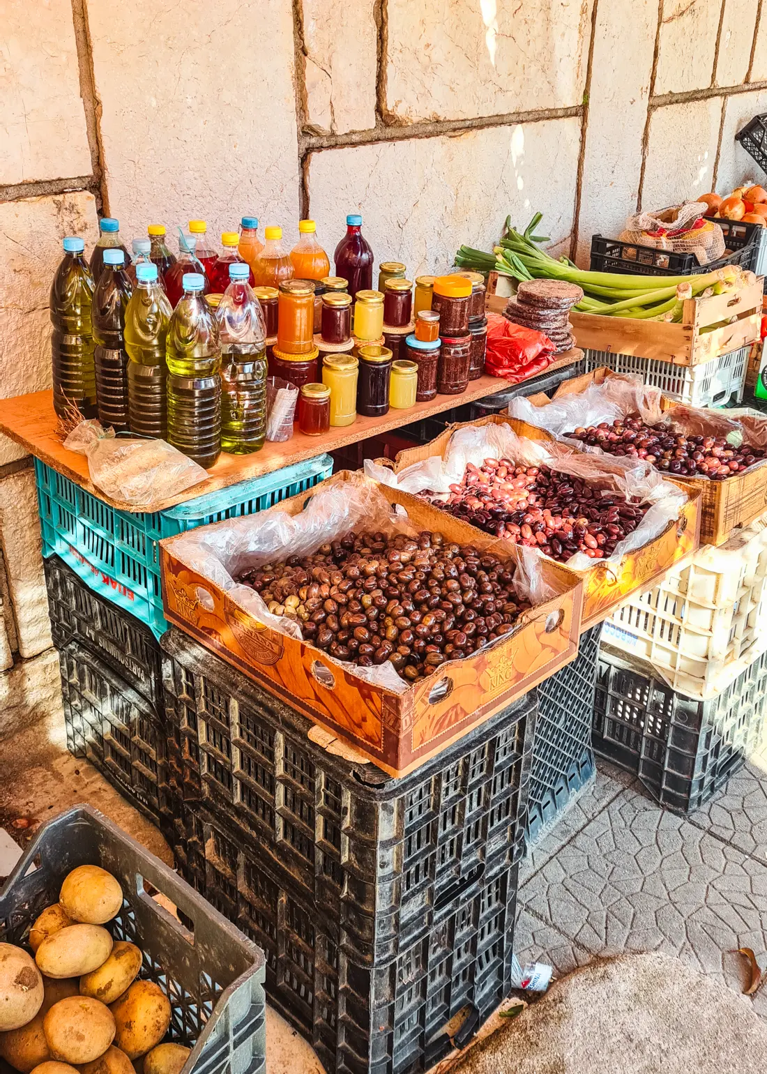 Black crates made into a table selling olives, olive oil and honey at the local farmer's market in Saranda, Albania.