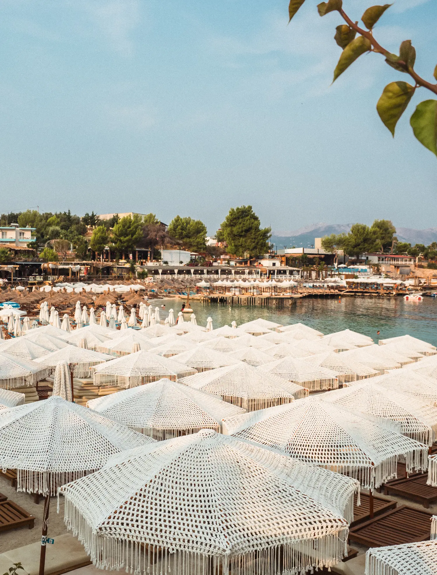 Poda Beach covered in crochet parasols on a sunny morning in Ksamil, Albania.