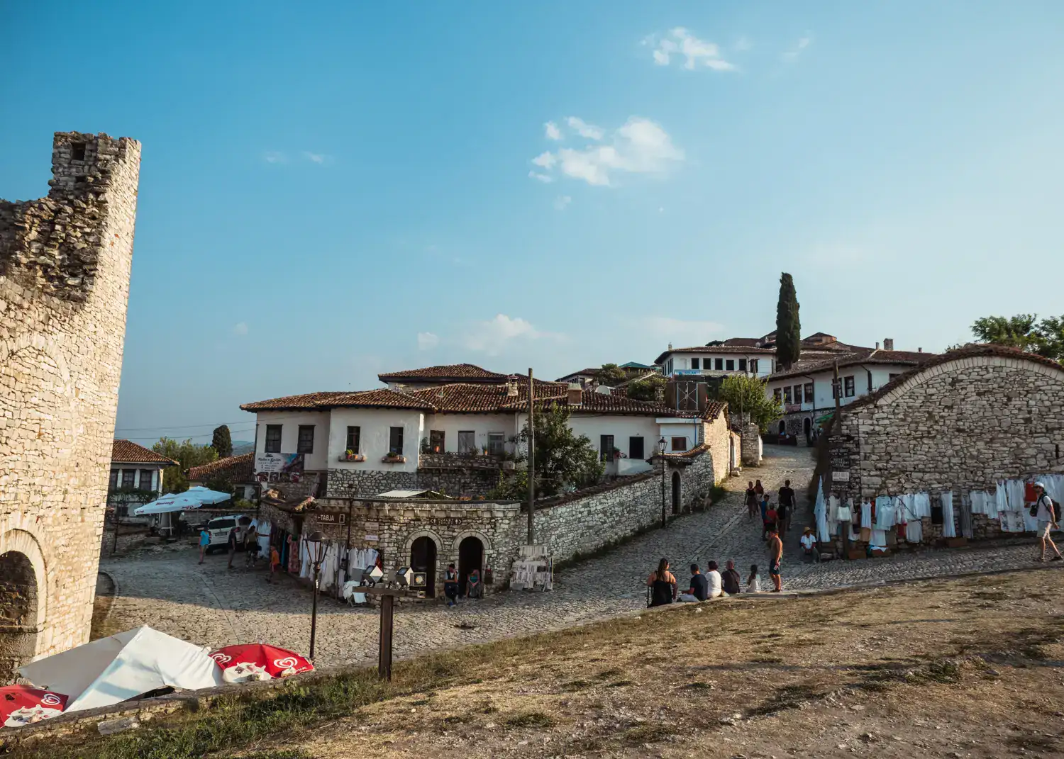 White houses with small windows and brown roofs on stone walls, cobbled streets, inside Berat Castle, one of the top things to do in Berat.