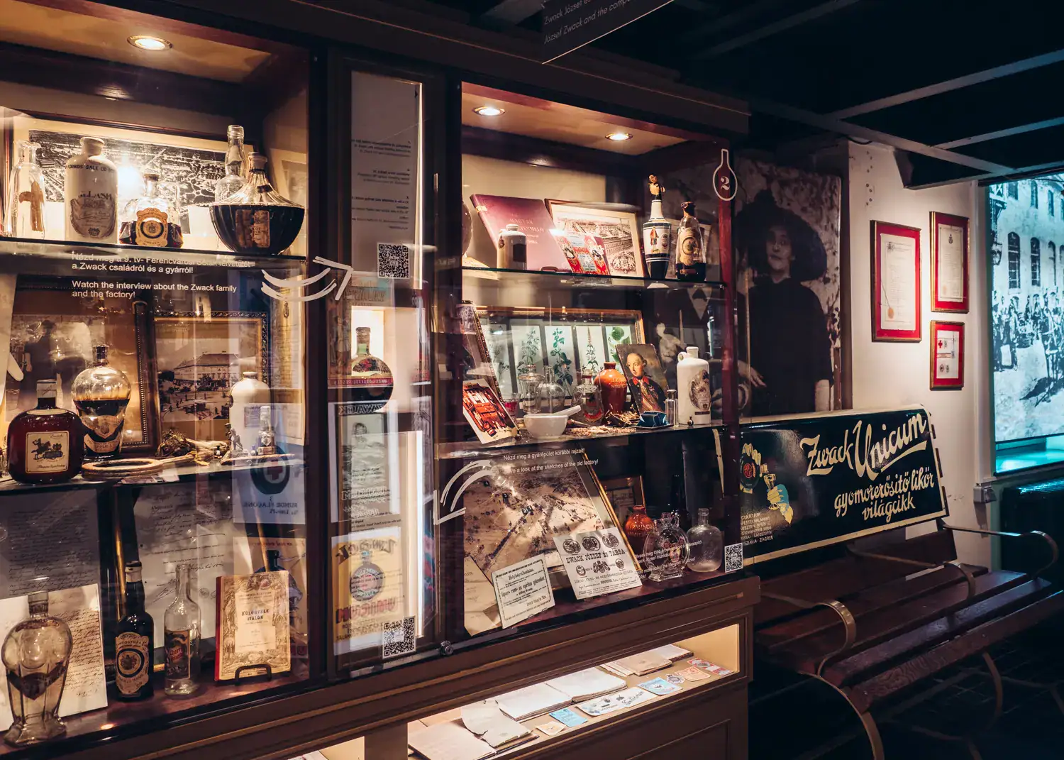 Glass shelves with old bottles, photos and information about the history of Zwack Unicum in Budapest.