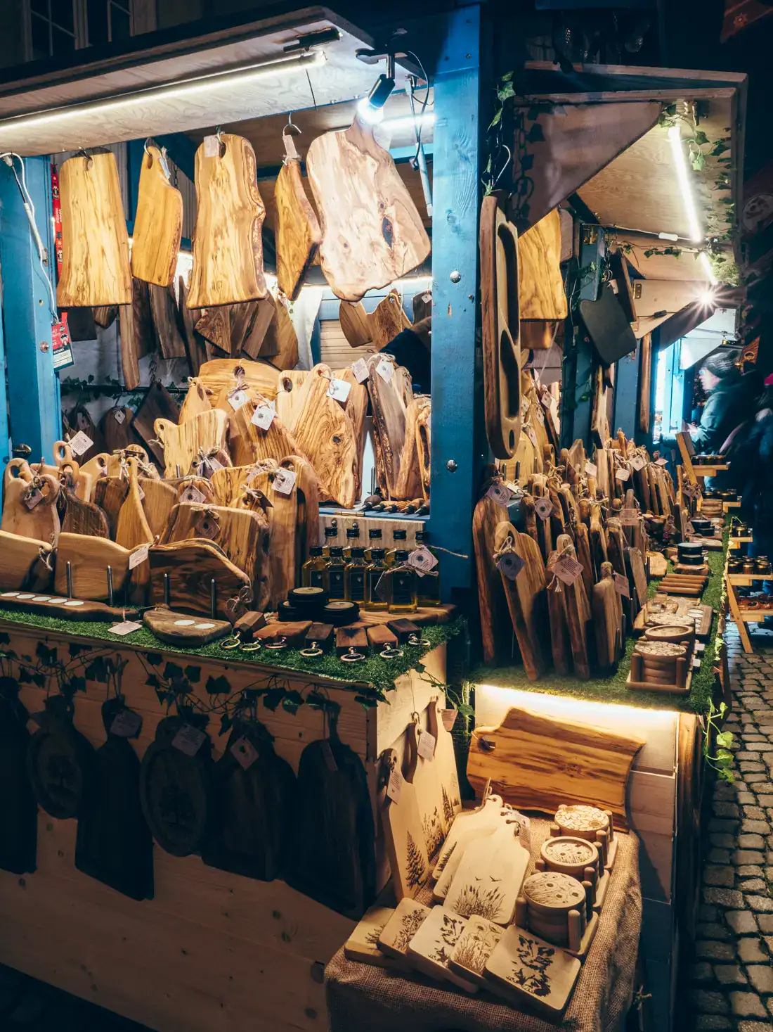 Blue stall selling wooded cutting boards, treys and utensils at Gdansk Christmas Market.