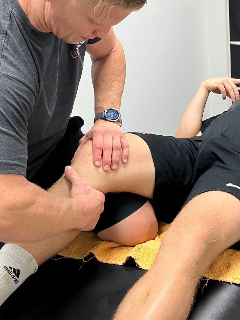 Stig undersøger SfB-spillerens knæ i forbindelse med behandling.