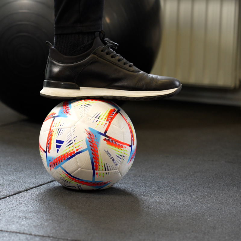  Fodboldspiller gennemgår specialiseret fysioterapi og træning med en fodbold på sportsklinikken