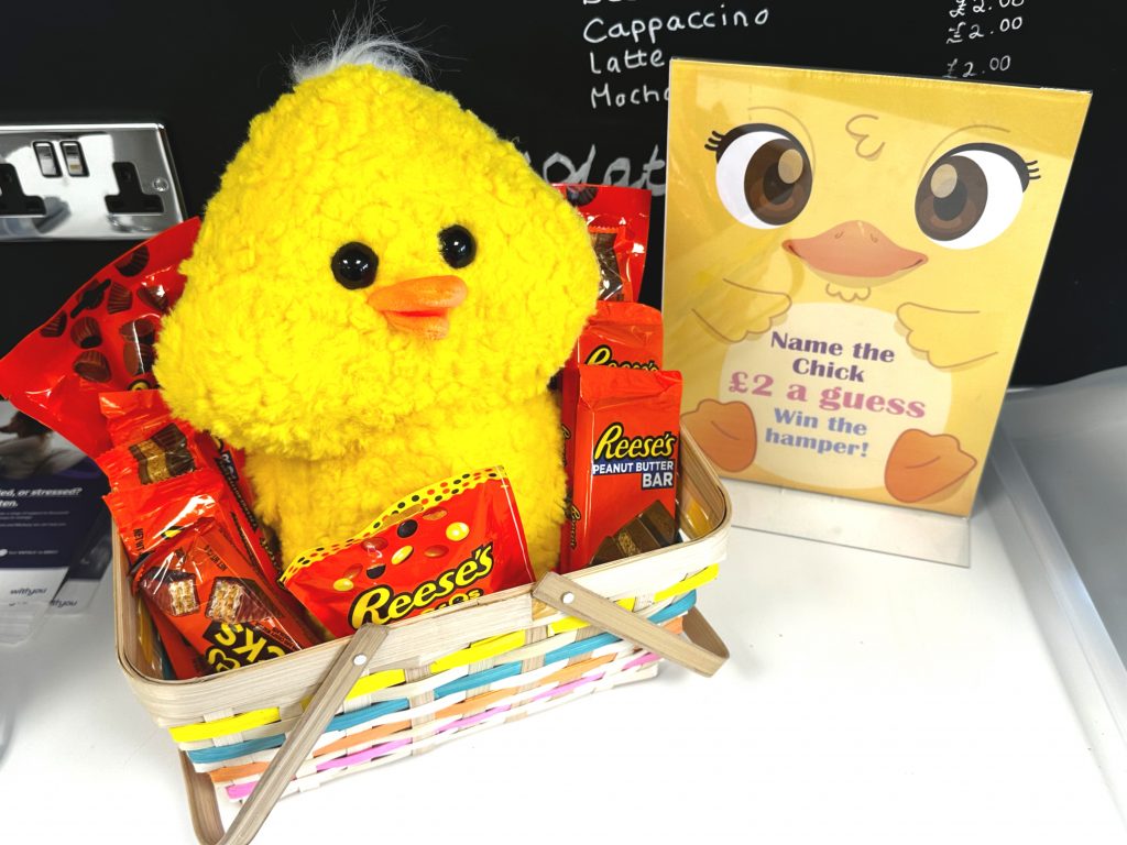 Image of the Easter Hamper - including a stuffed chick and multiple bars of chocolate.