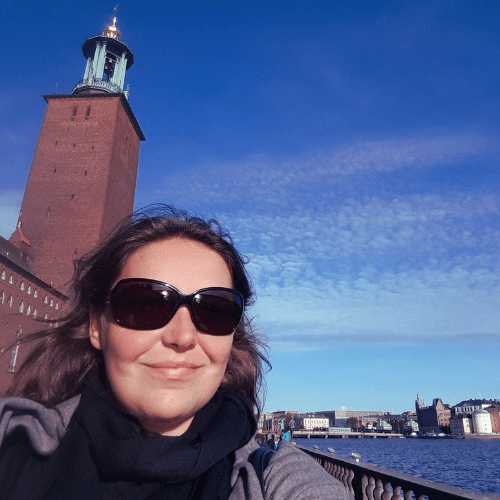 Profile picture of owner, writer and content creator Heidi from Take me to Sweden in front of Stadshuset in Stockholm, Sweden.