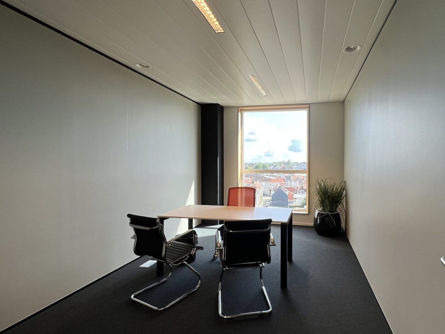 Een kantoor met strakke lijnen en moderne meubels, perfect voor zakelijke vergaderingen