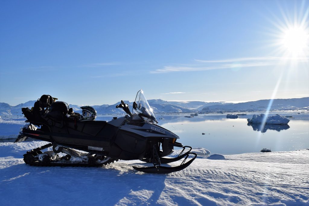 Snowmobile and view over Sermilik Fjord