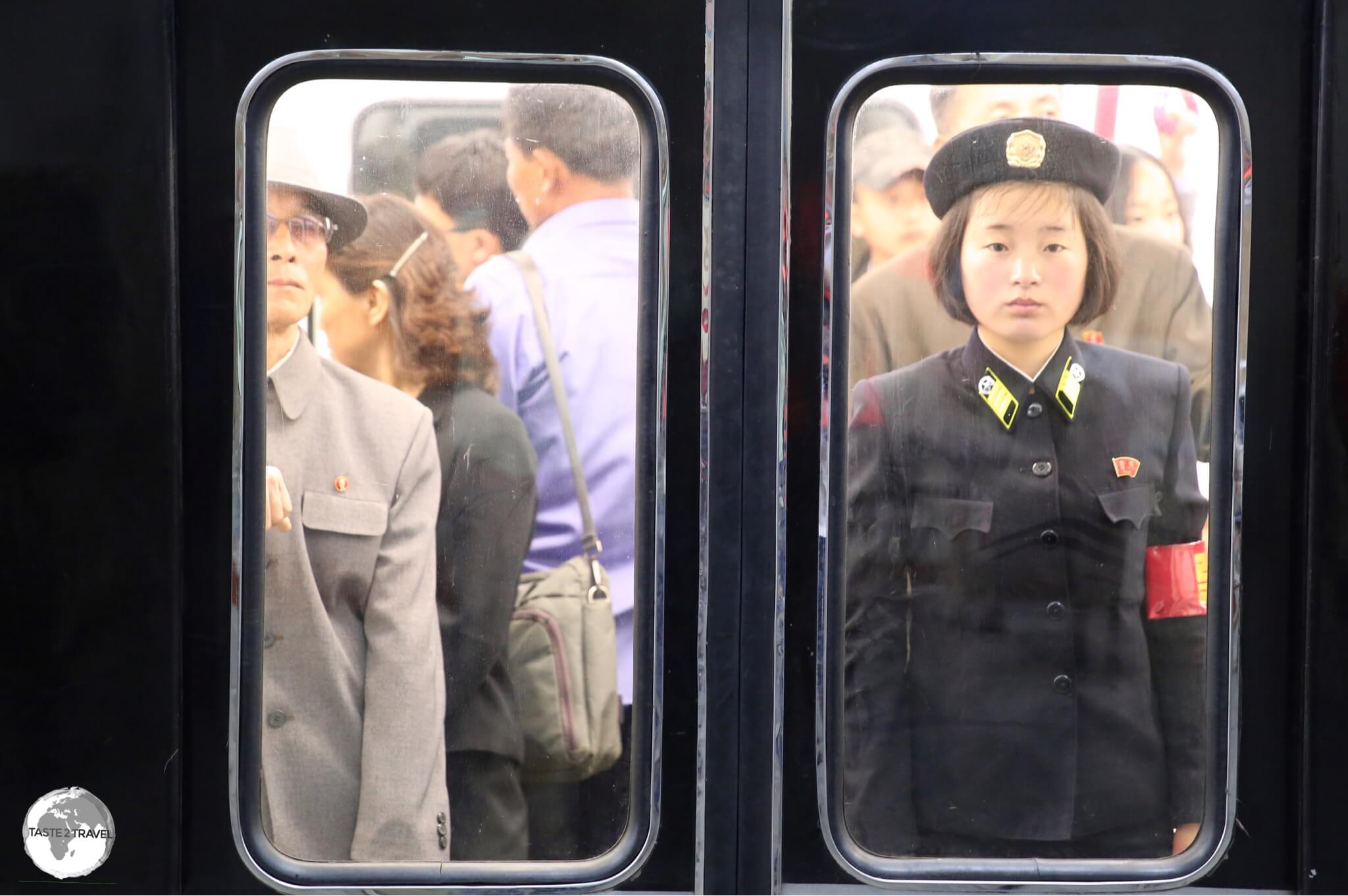 A Pyongyang metro guard, standing at attention, on a departing train at Yonggwang metro station.