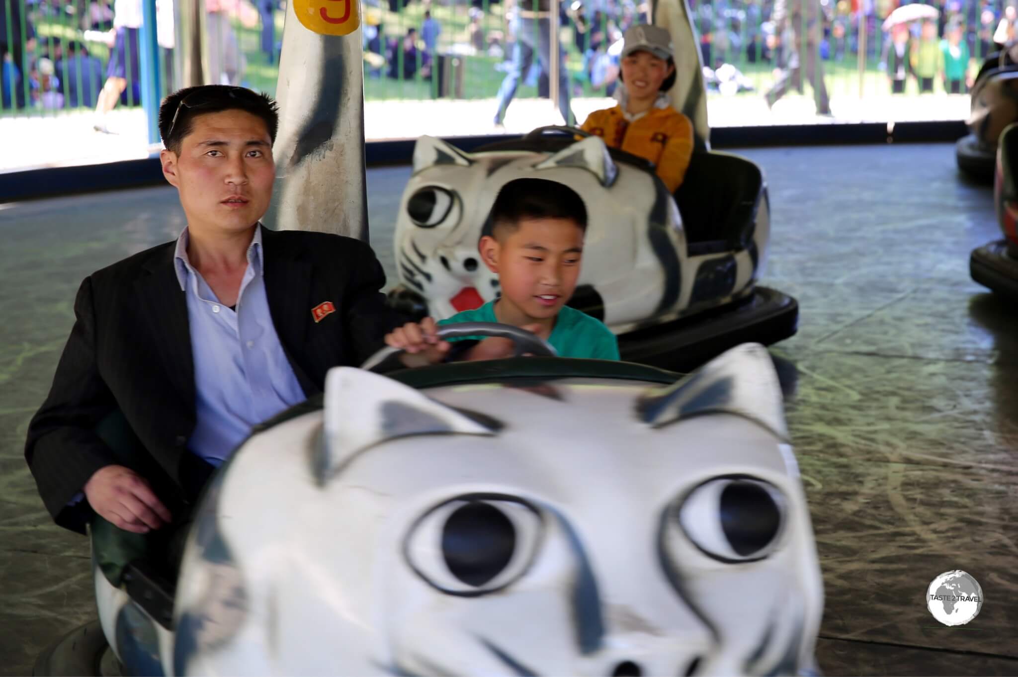 Father and son riding the bumper cars at Taesongsan Fun Fair in Pyongyang.