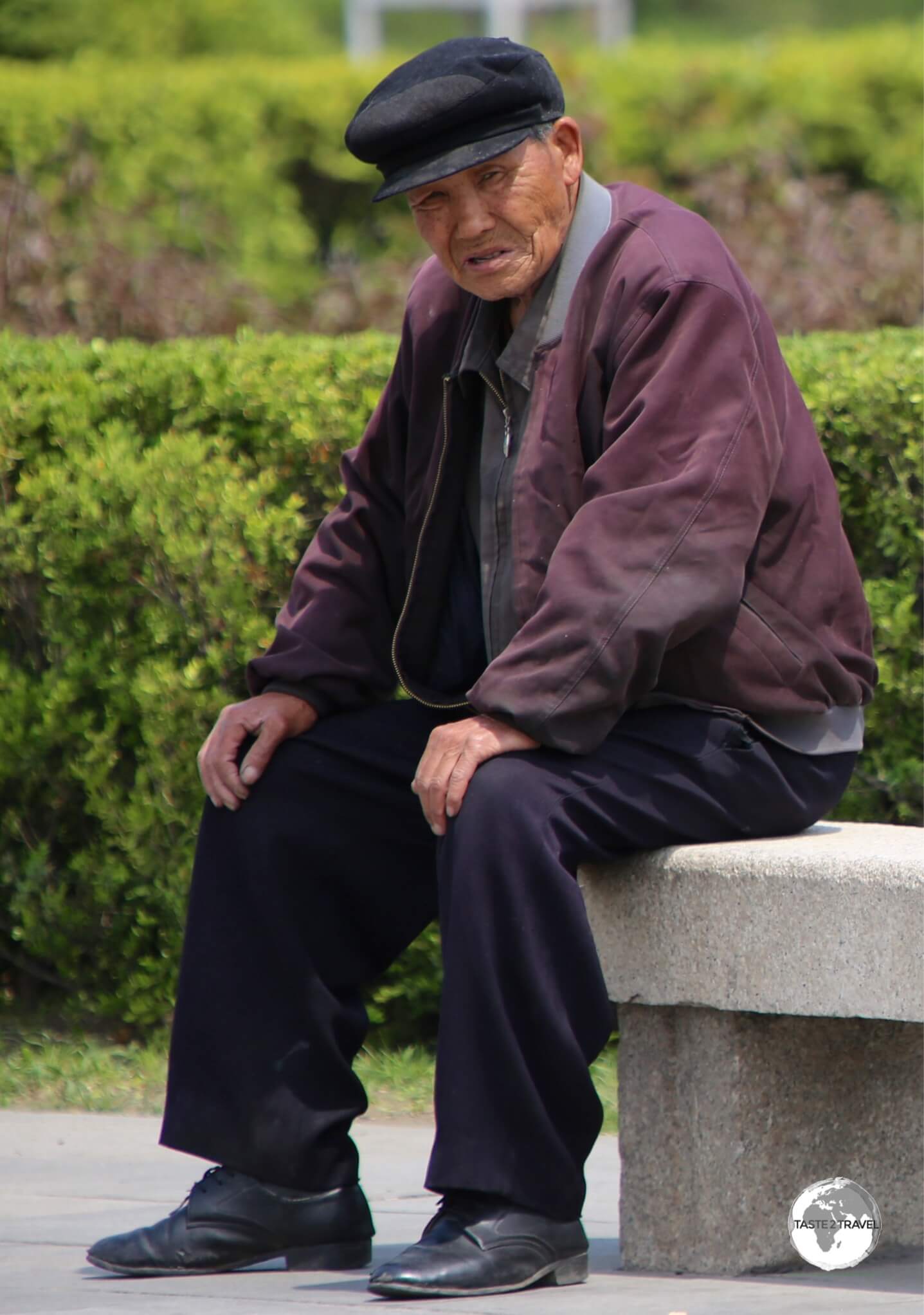 An old man relaxing at the <i>Monument to Party Founding</i> in Pyongyang.