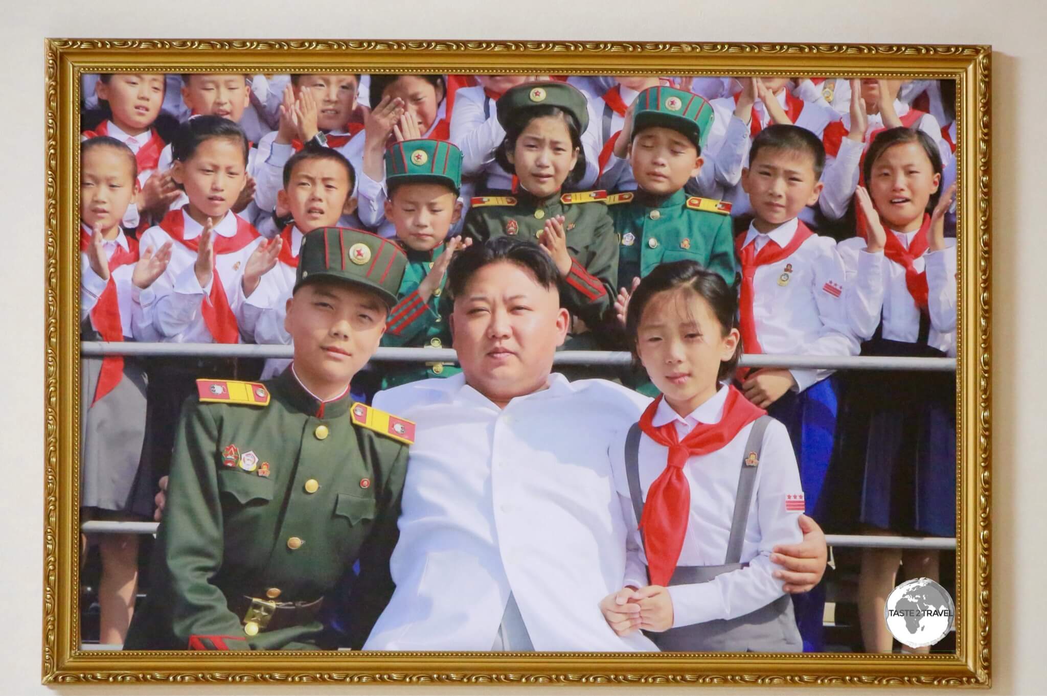 Although current leader Kim Jong-un's image is not displayed publicly, there are photos and paintings of him featured in galleries. Notice the children behind him are crying tears of joy.