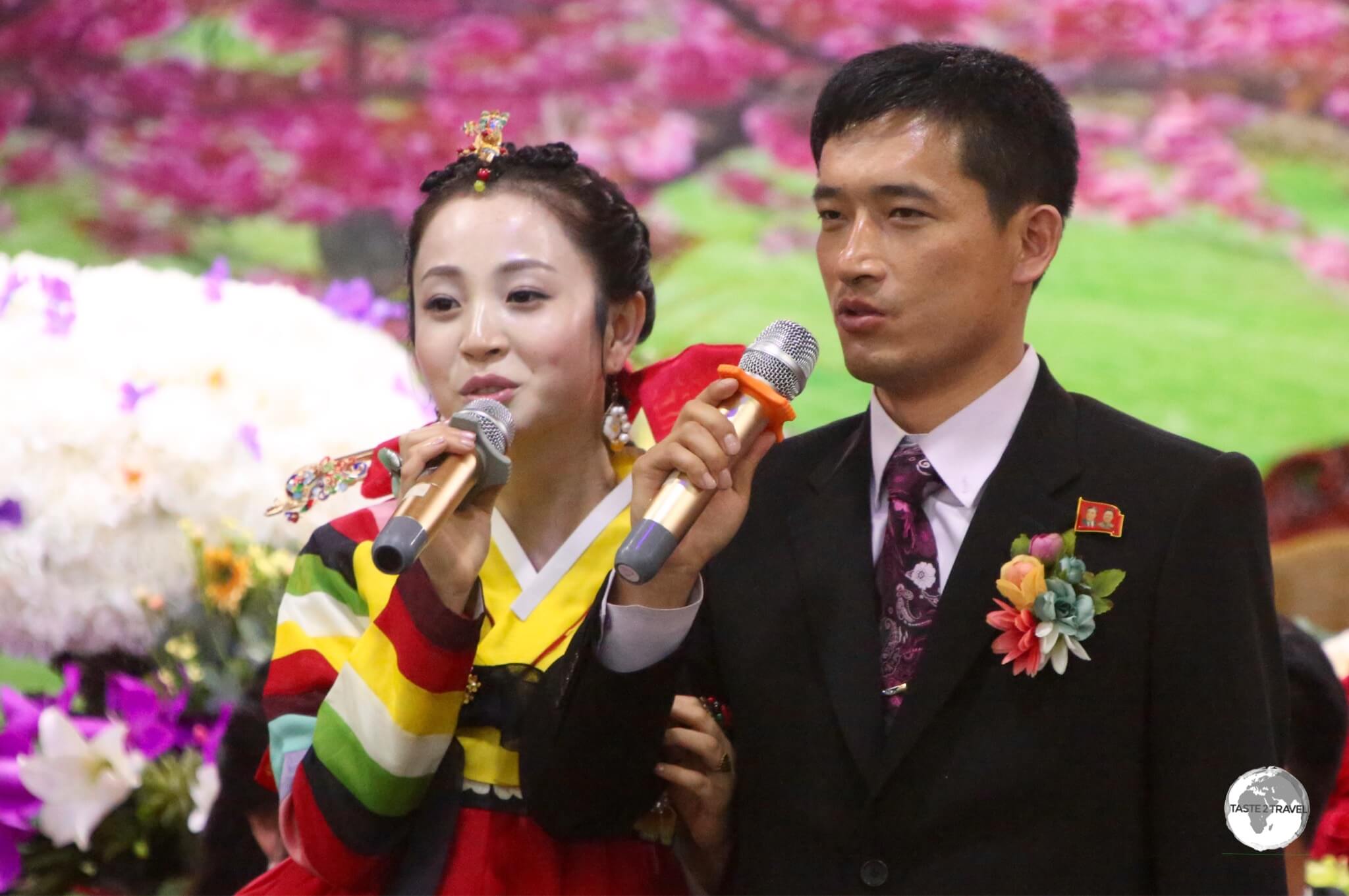 Newlyweds performing Karaoke at their wedding reception which was held in a private room at a bar in Pyongyang.