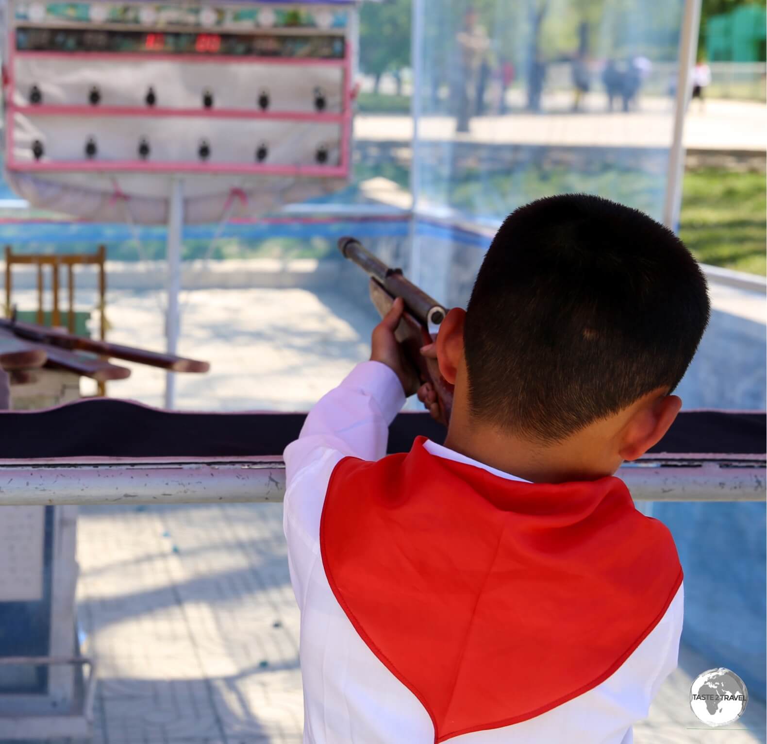 A young school boy tries his luck at a shooting alley at Taesongsan Fun Fair in Pyongyang.