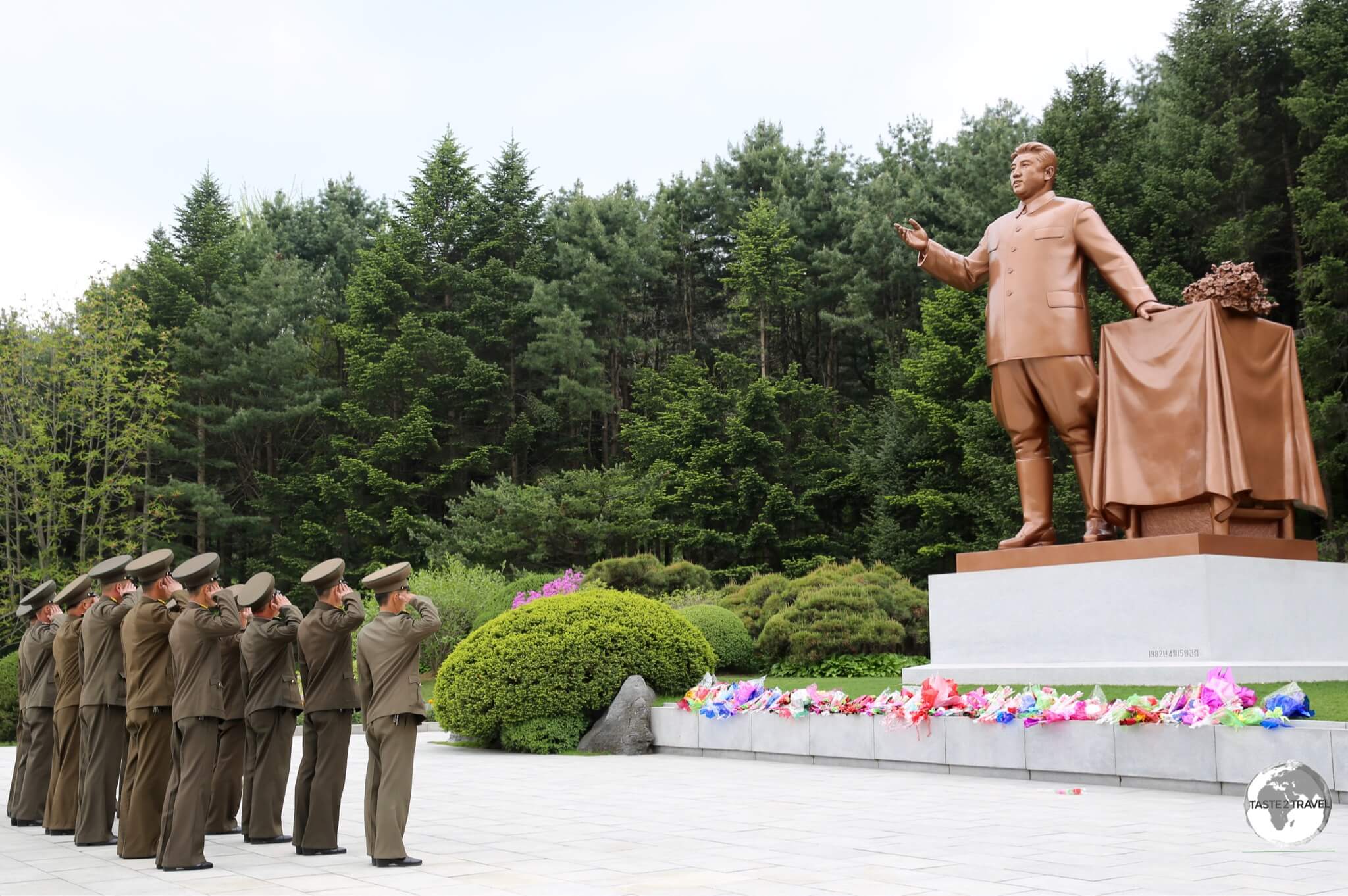 Soldiers salute in front of a statue of Kim Il-sung, in a park on the outskirts of Pyongyang.